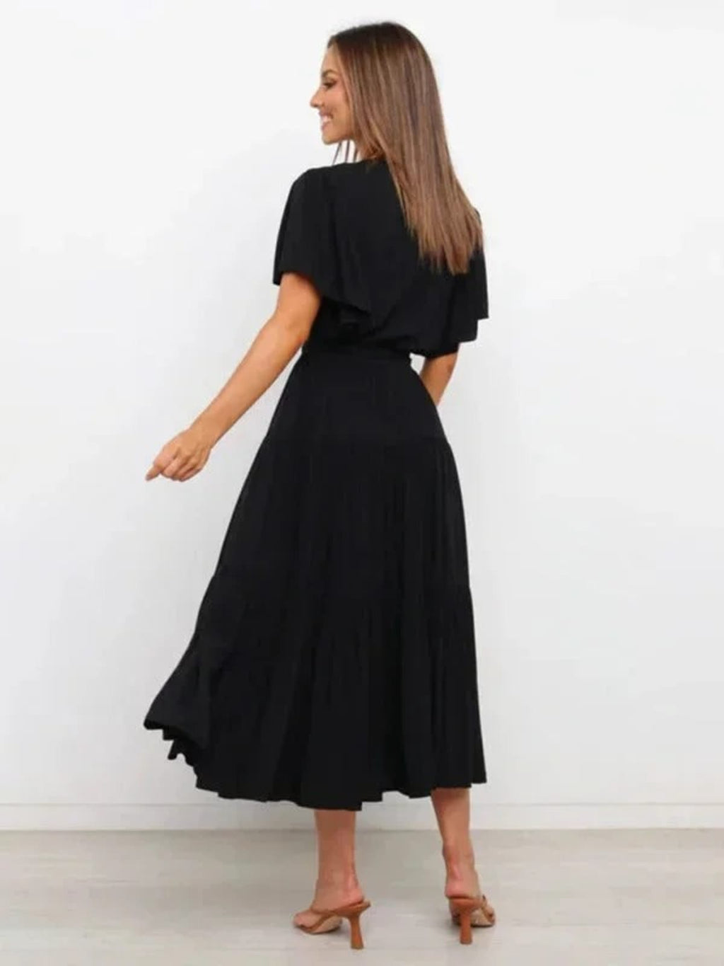 Woman in rust-colored midi dress with V-neck and tie waist.