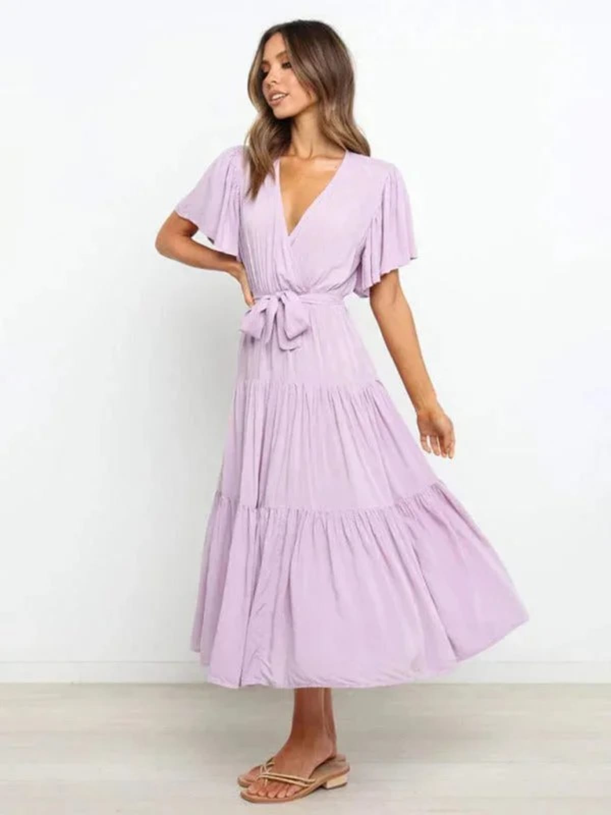 Woman in rust-colored midi dress with V-neck and tie waist.