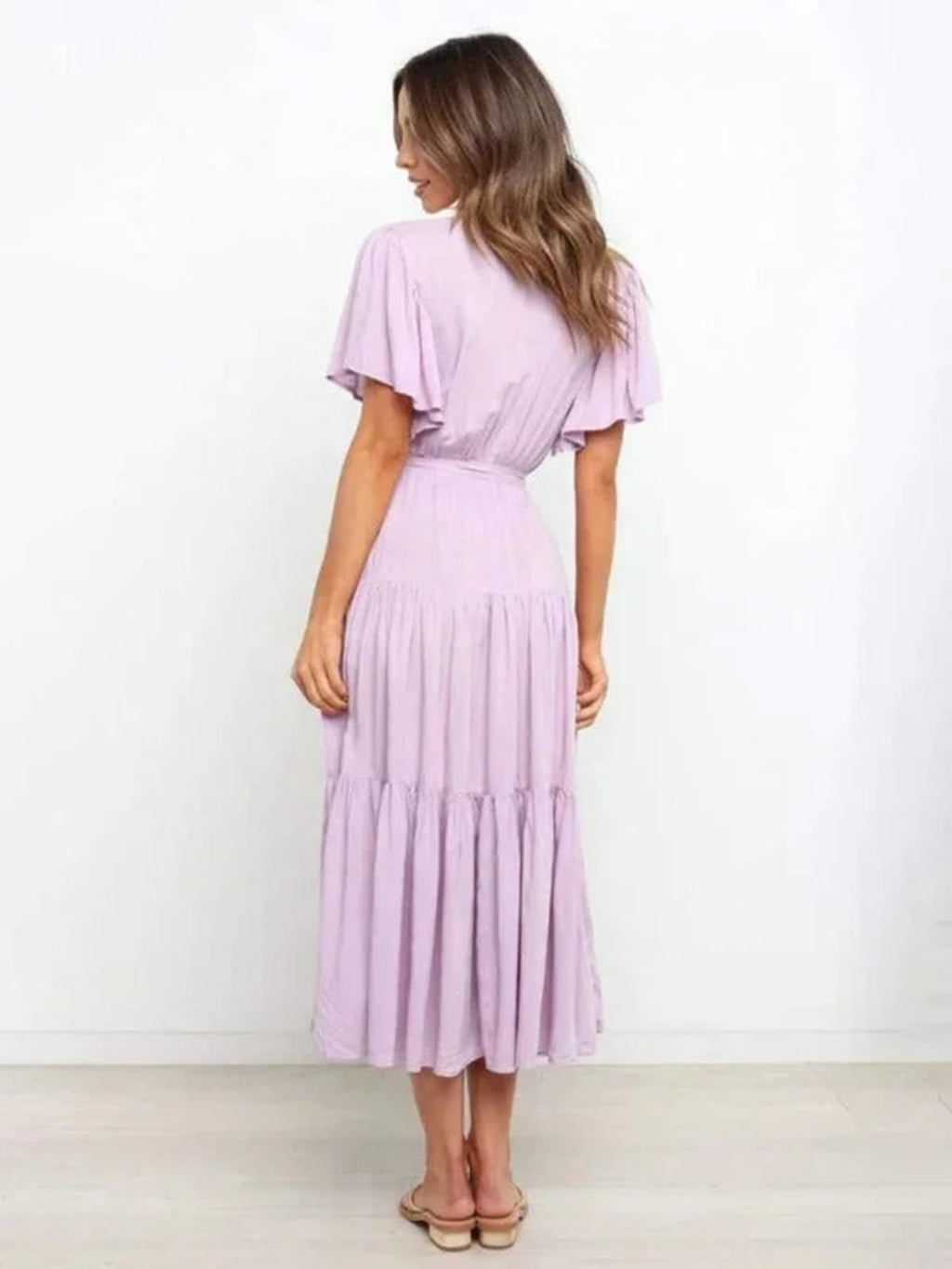 Woman in rust-colored midi dress with V-neck and tie waist.
