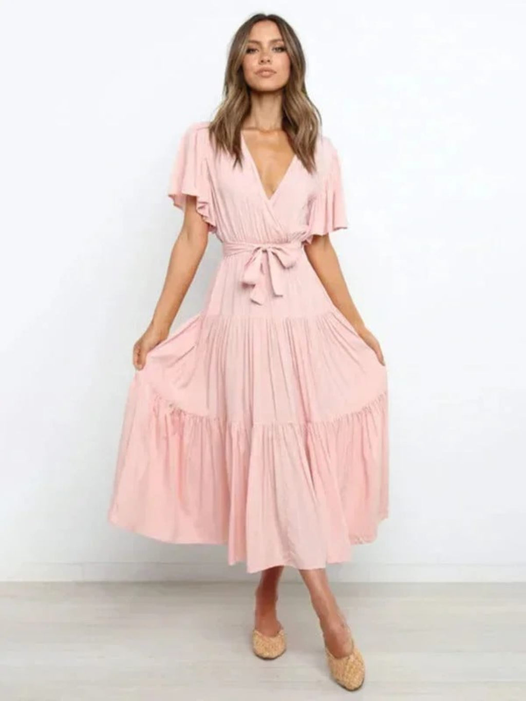 Woman in rust-colored midi dress with V-neck and tie waist.