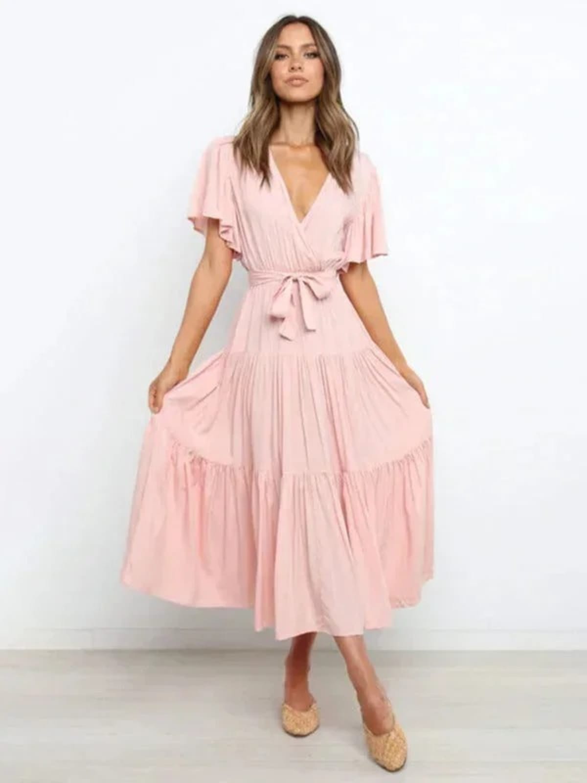 Woman in rust-colored midi dress with V-neck and tie waist.