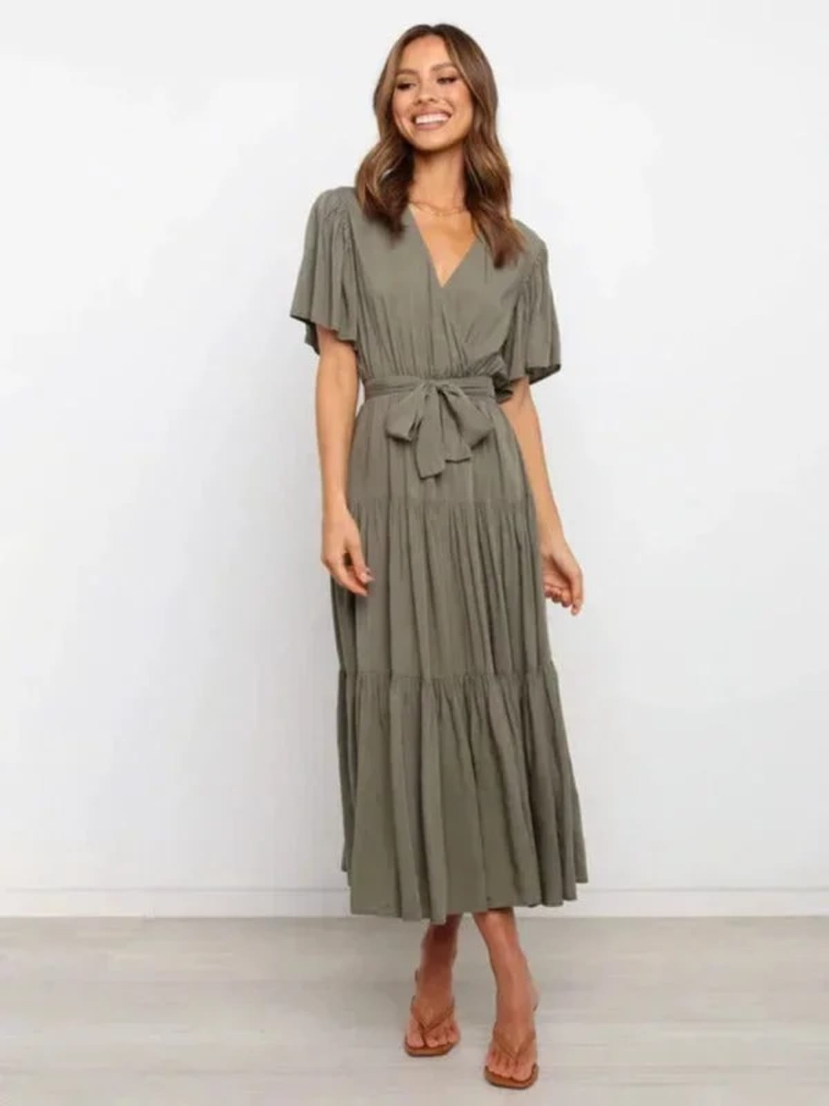 Woman in rust-colored midi dress with V-neck and tie waist.
