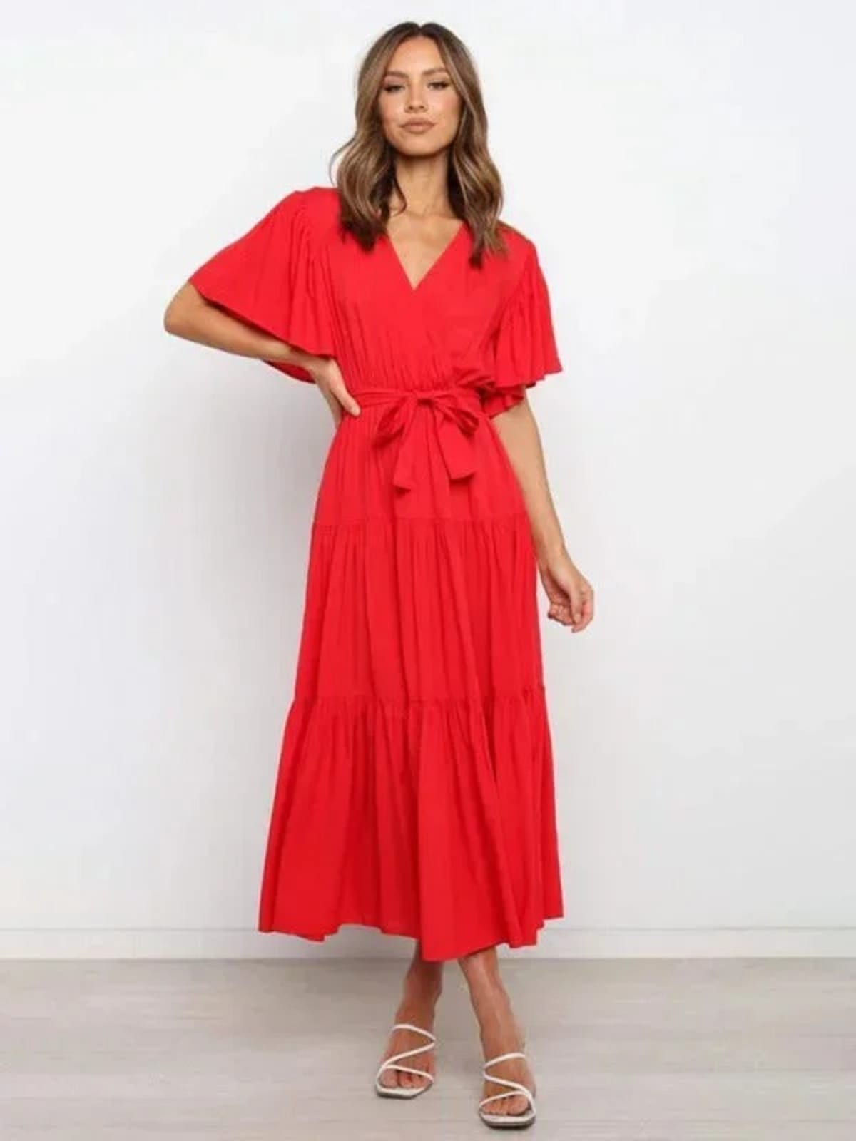 Woman in rust-colored midi dress with V-neck and tie waist.
