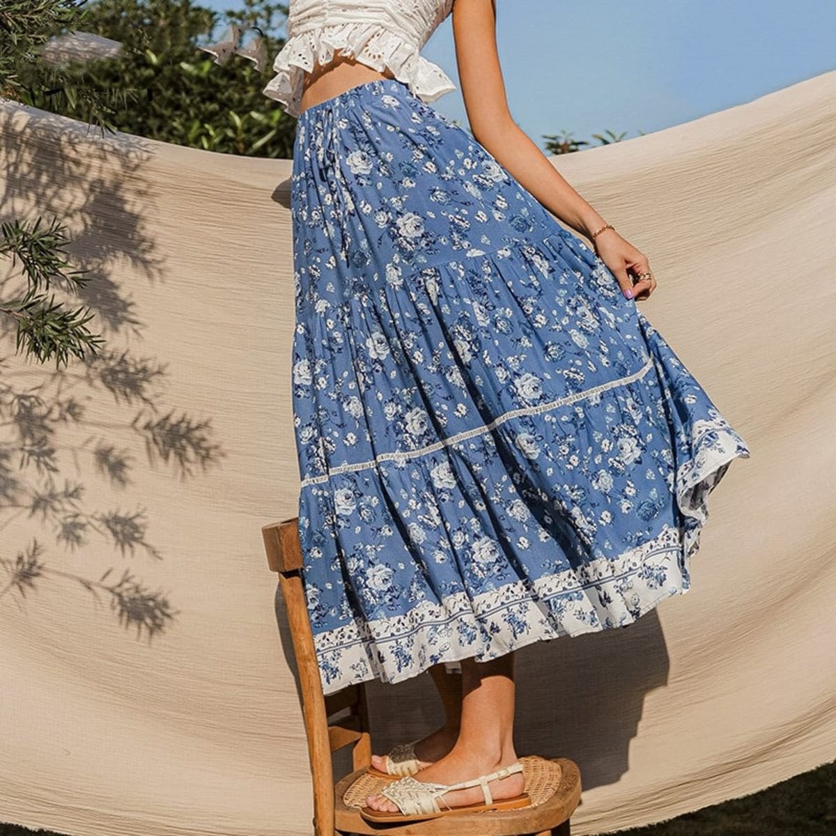 Woman wearing floral tiered maxi skirt with patterned hem outdoors