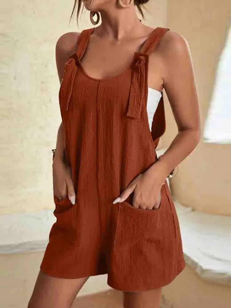 Women's romper with tie-strap shoulders and front pockets.