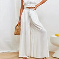 High-waisted wide-leg pants with smocked waistband and drawstring.
