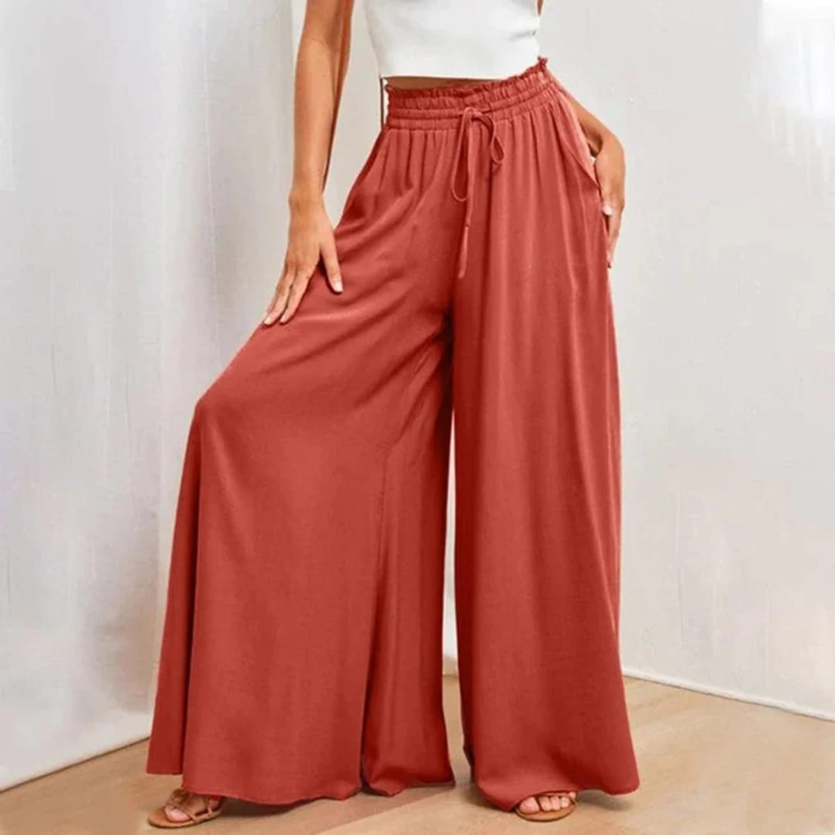 High-waisted wide-leg pants with smocked waistband and drawstring.