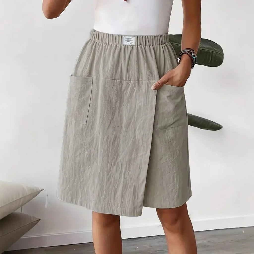Woman wearing a wrap-style A-line skirt with elastic waistband and pockets.