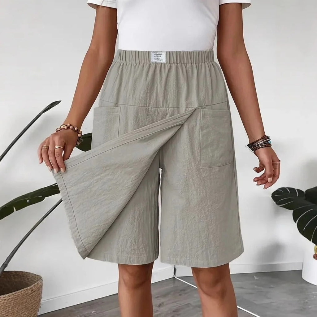 Woman wearing a wrap-style A-line skirt with elastic waistband and pockets.