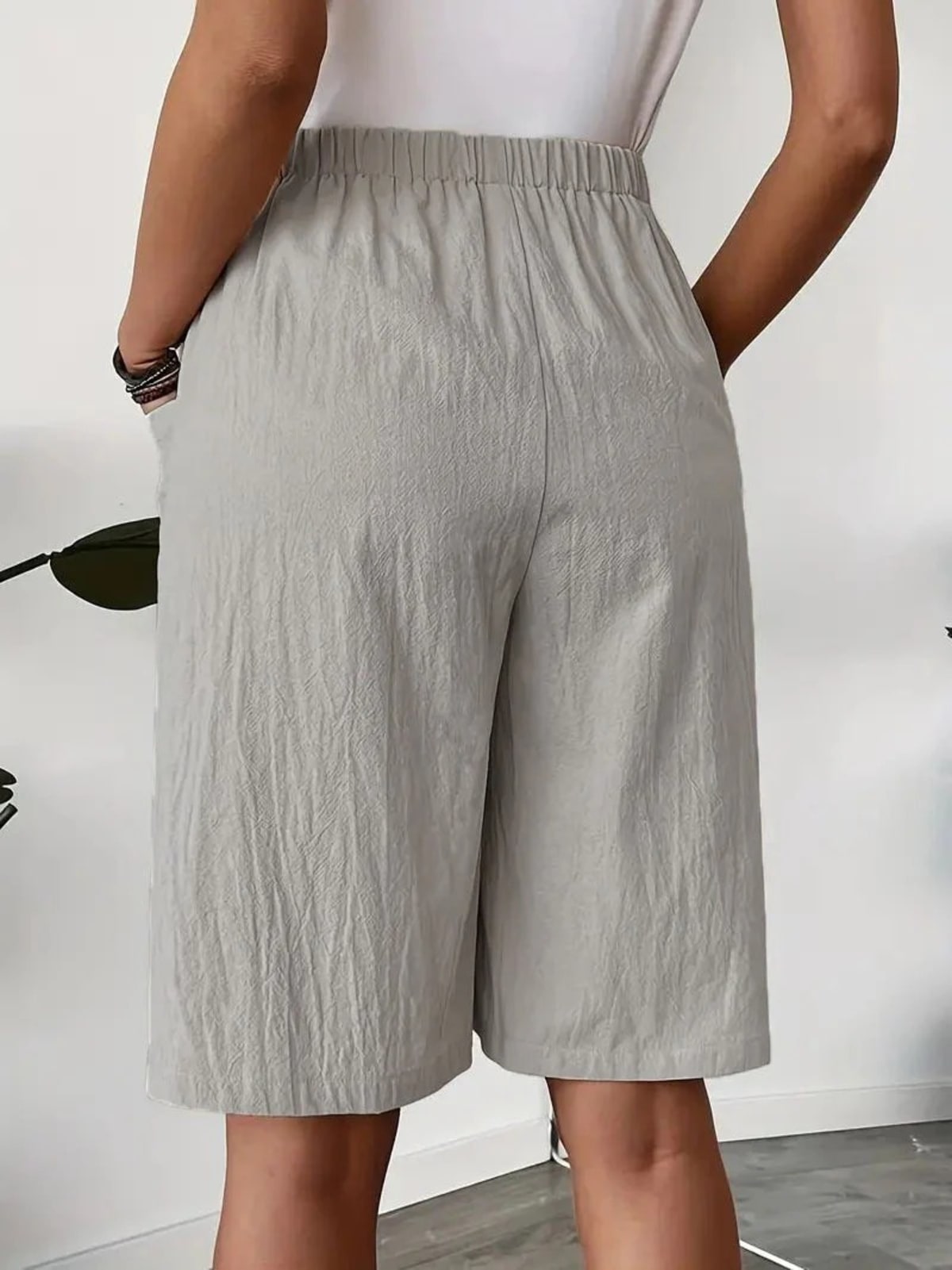 Woman wearing a wrap-style A-line skirt with elastic waistband and pockets.