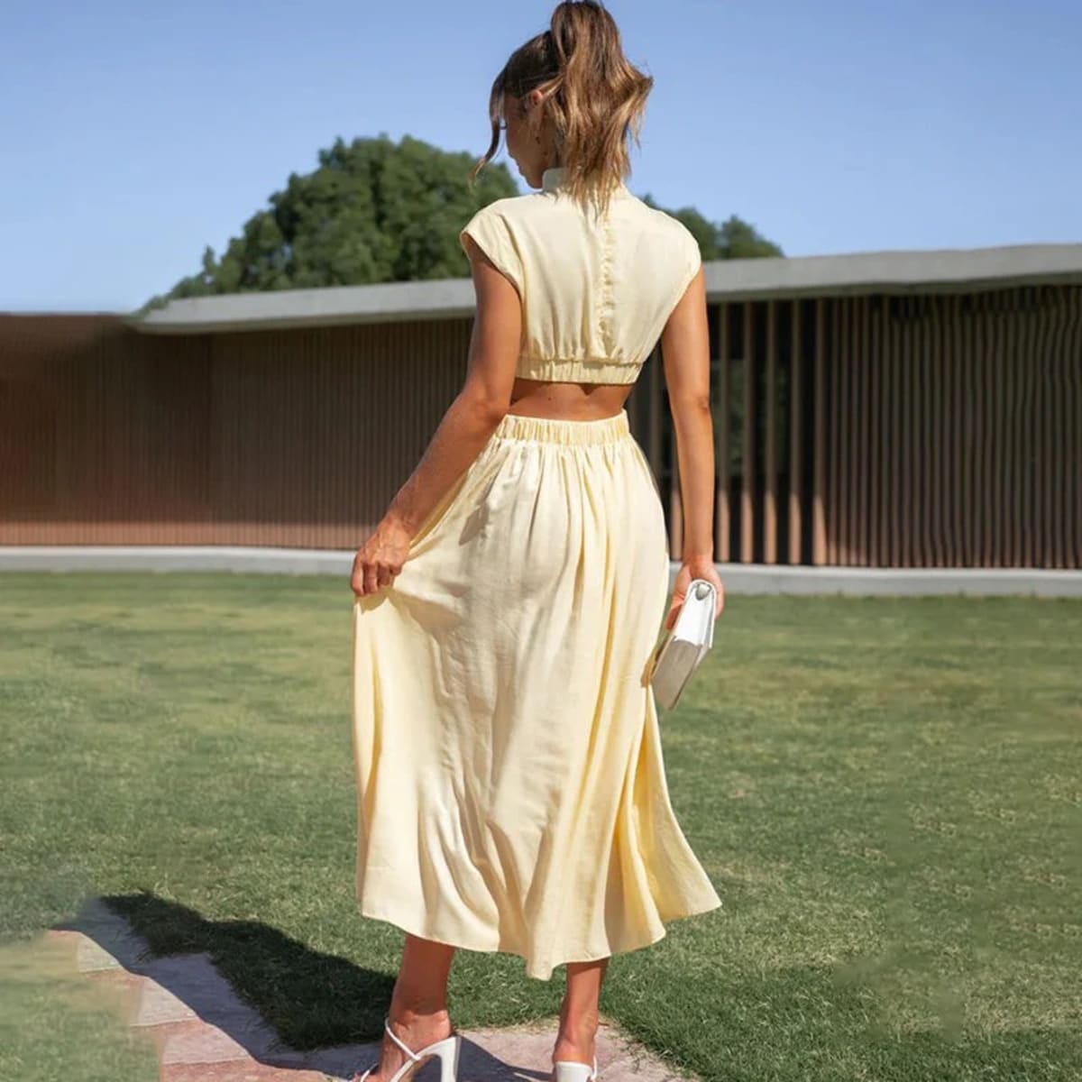 Woman wearing a halter neck flowing dress outdoors.
