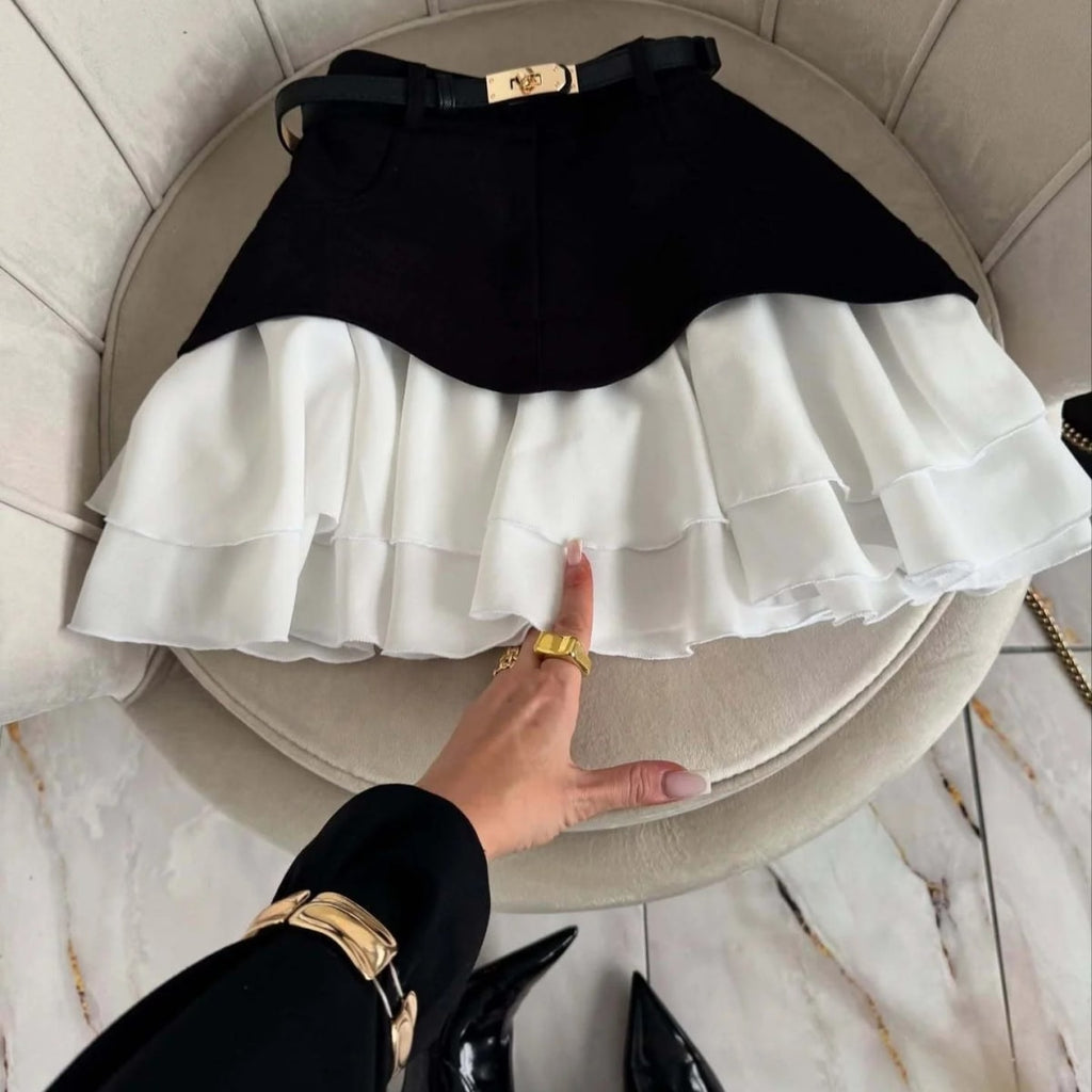 Woman in elevator wearing layered ruffle skirt with long sleeve top.