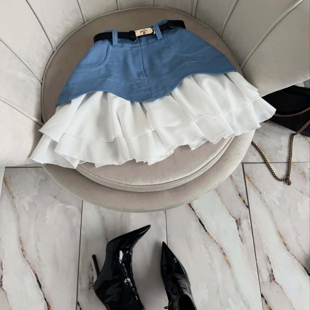 Woman in elevator wearing layered ruffle skirt with long sleeve top.