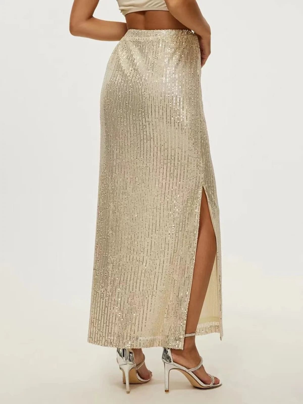 Model wearing a sequin maxi skirt with high side slit.