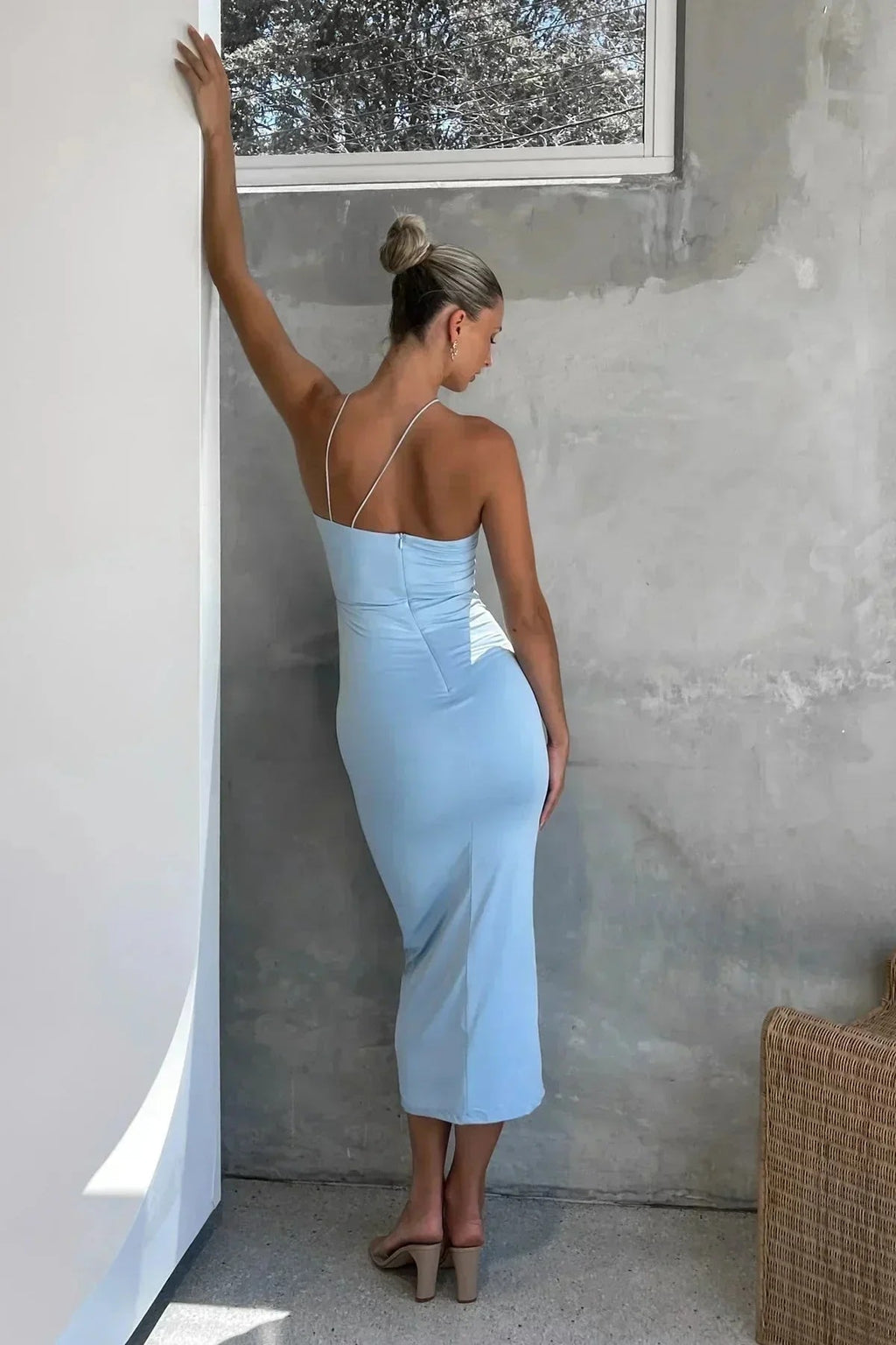 Model in bodycon midi dress with ruched bodice, asymmetric strap, 3D flower.