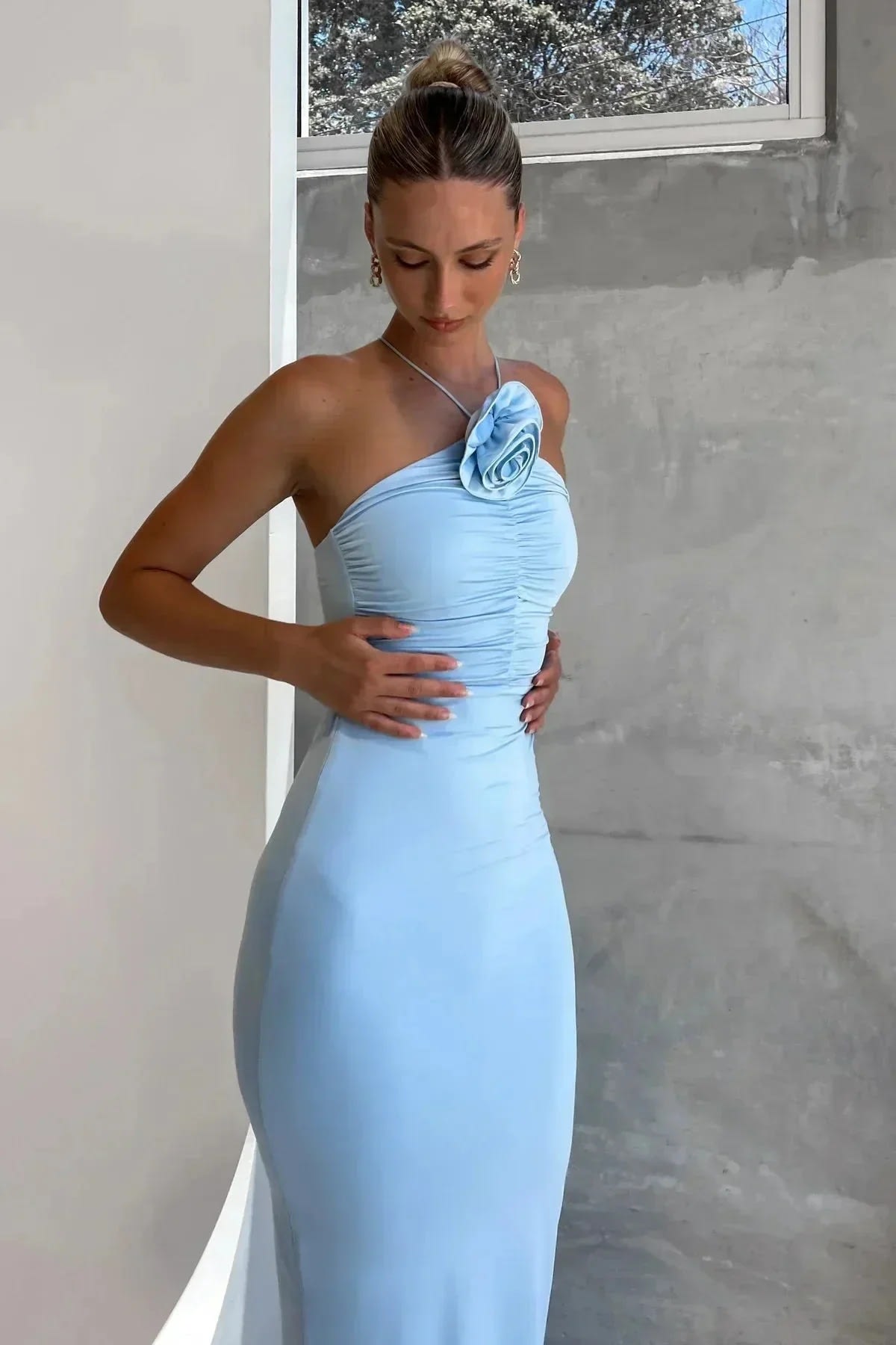 Model in bodycon midi dress with ruched bodice, asymmetric strap, 3D flower.