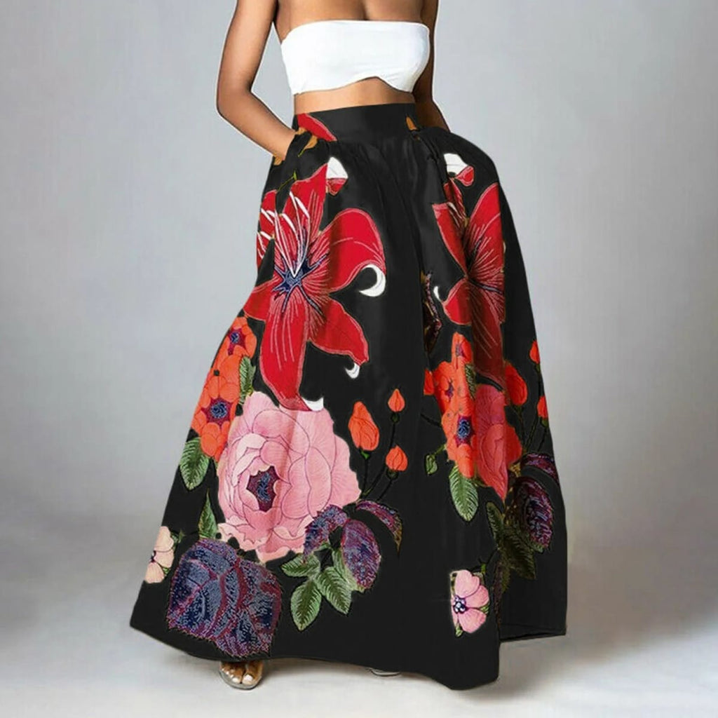 Woman wearing a vibrant floral maxi skirt with red lilies, pink peonies.