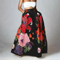Woman wearing a vibrant floral maxi skirt with red lilies, pink peonies.