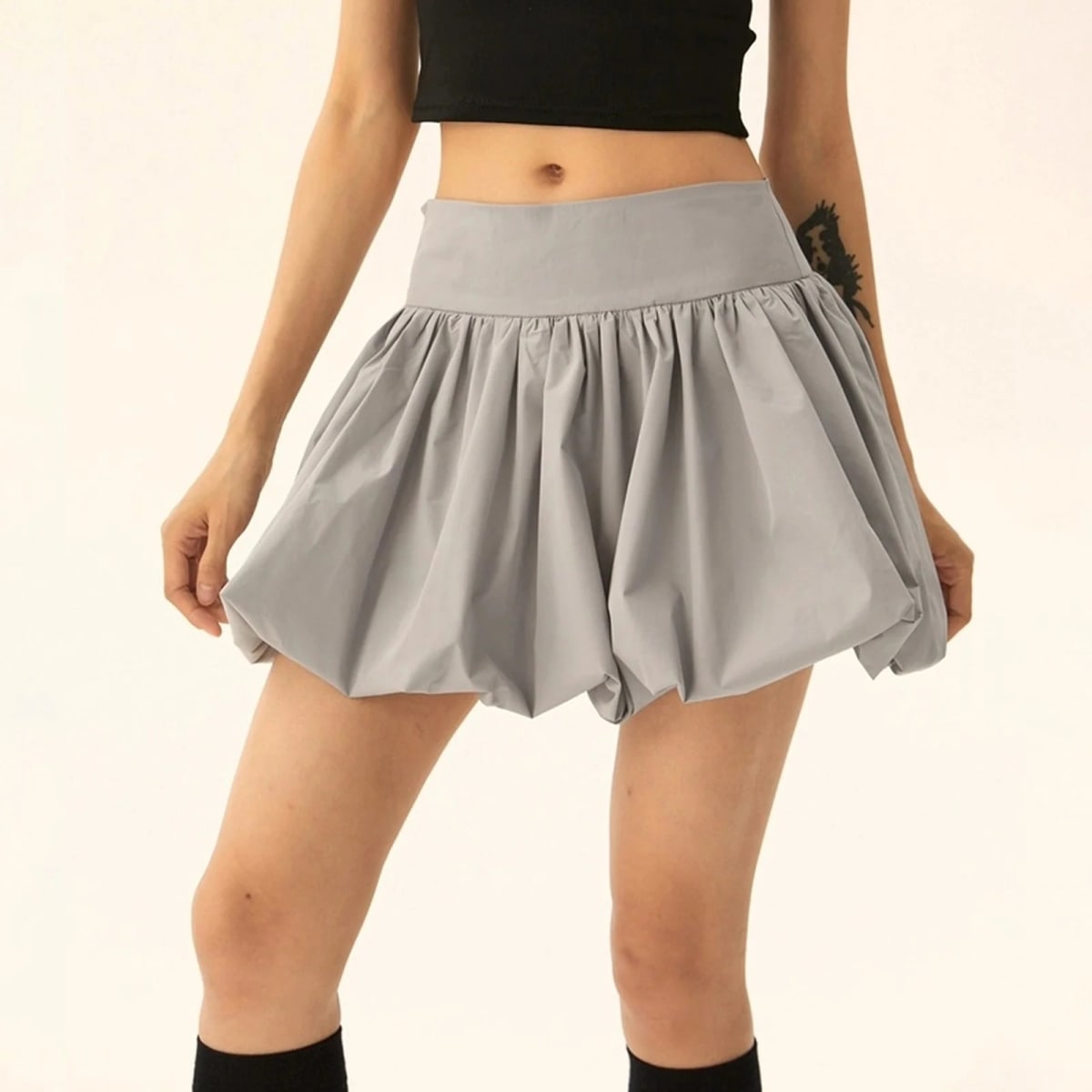 Model wearing a puffy mini skirt with bubble silhouette and high waist.