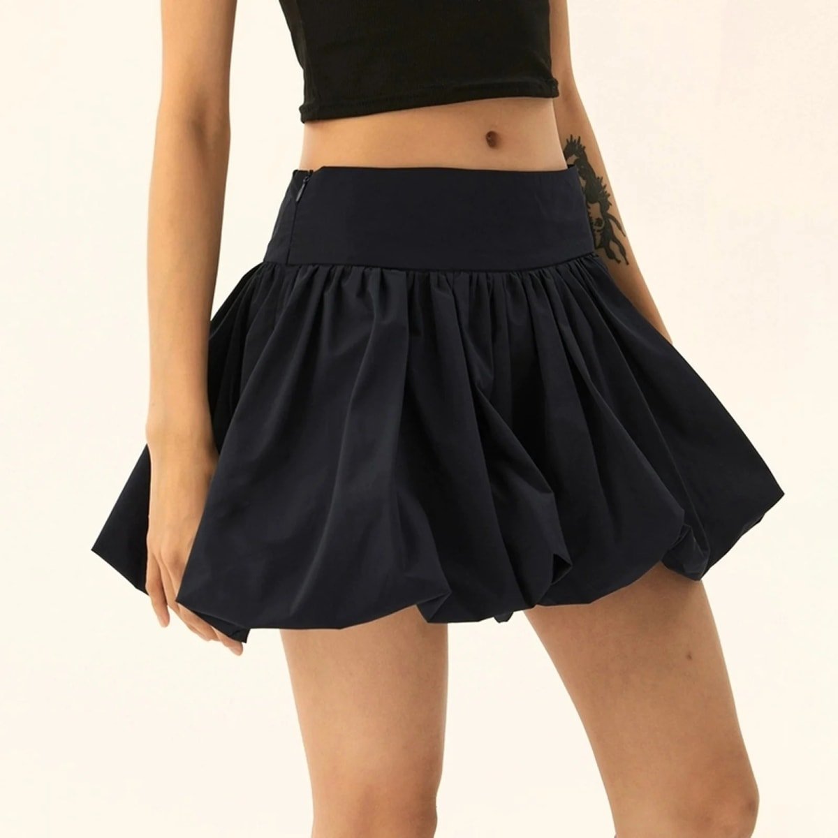 Model wearing a puffy mini skirt with bubble silhouette and high waist.