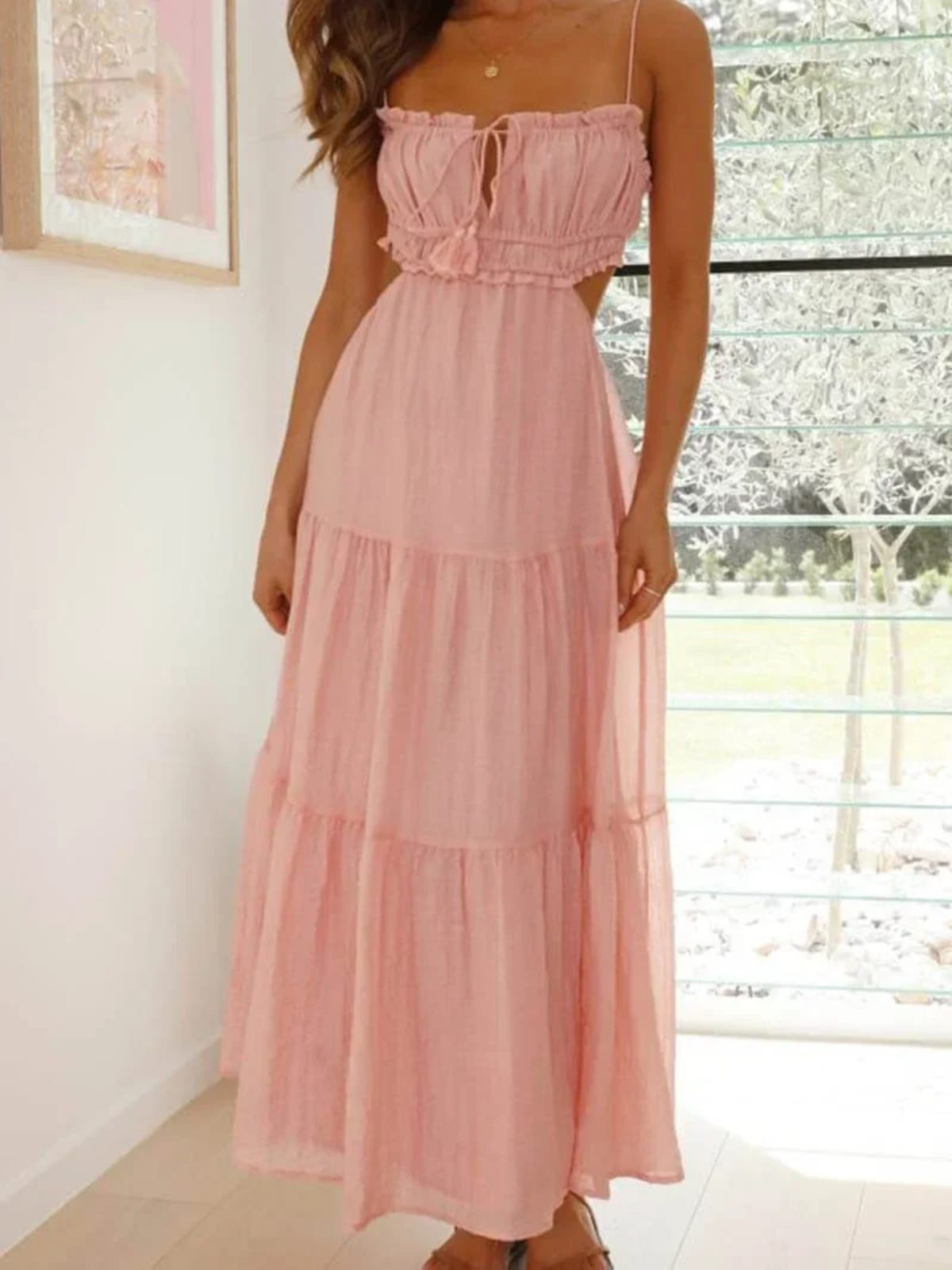 Woman in tiered midi dress with cut-outs and tassels.