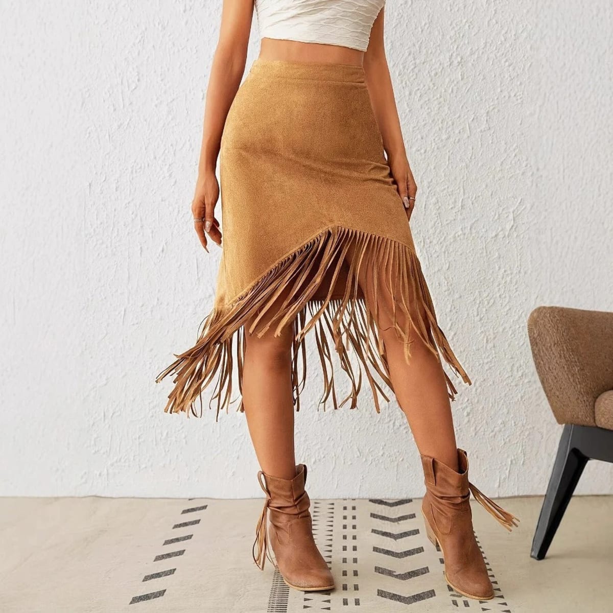 Woman wearing a midi skirt with fringe trim and asymmetrical hem.