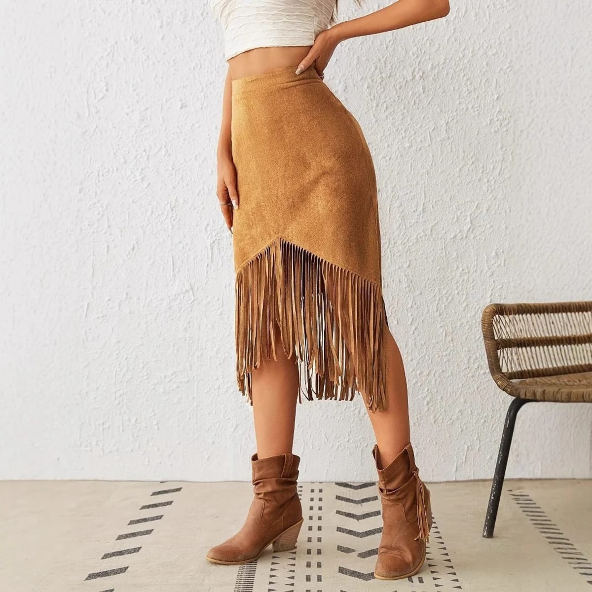 Woman wearing a midi skirt with fringe trim and asymmetrical hem.