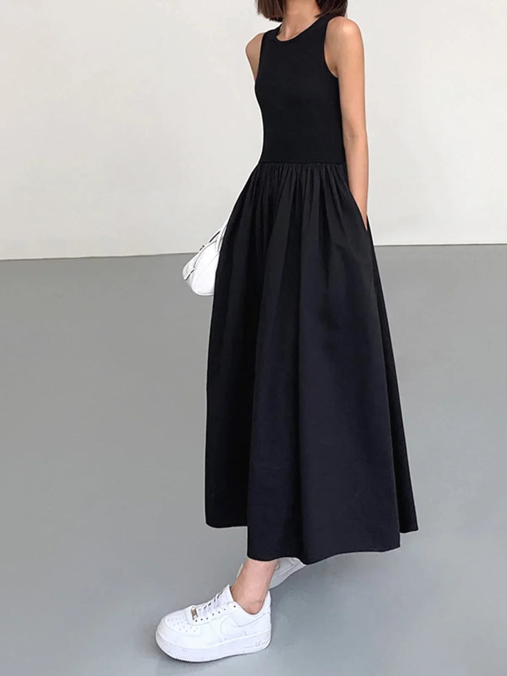 Person wearing a sleeveless maxi dress with a gathered skirt.