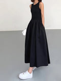 Person wearing a sleeveless maxi dress with a gathered skirt.