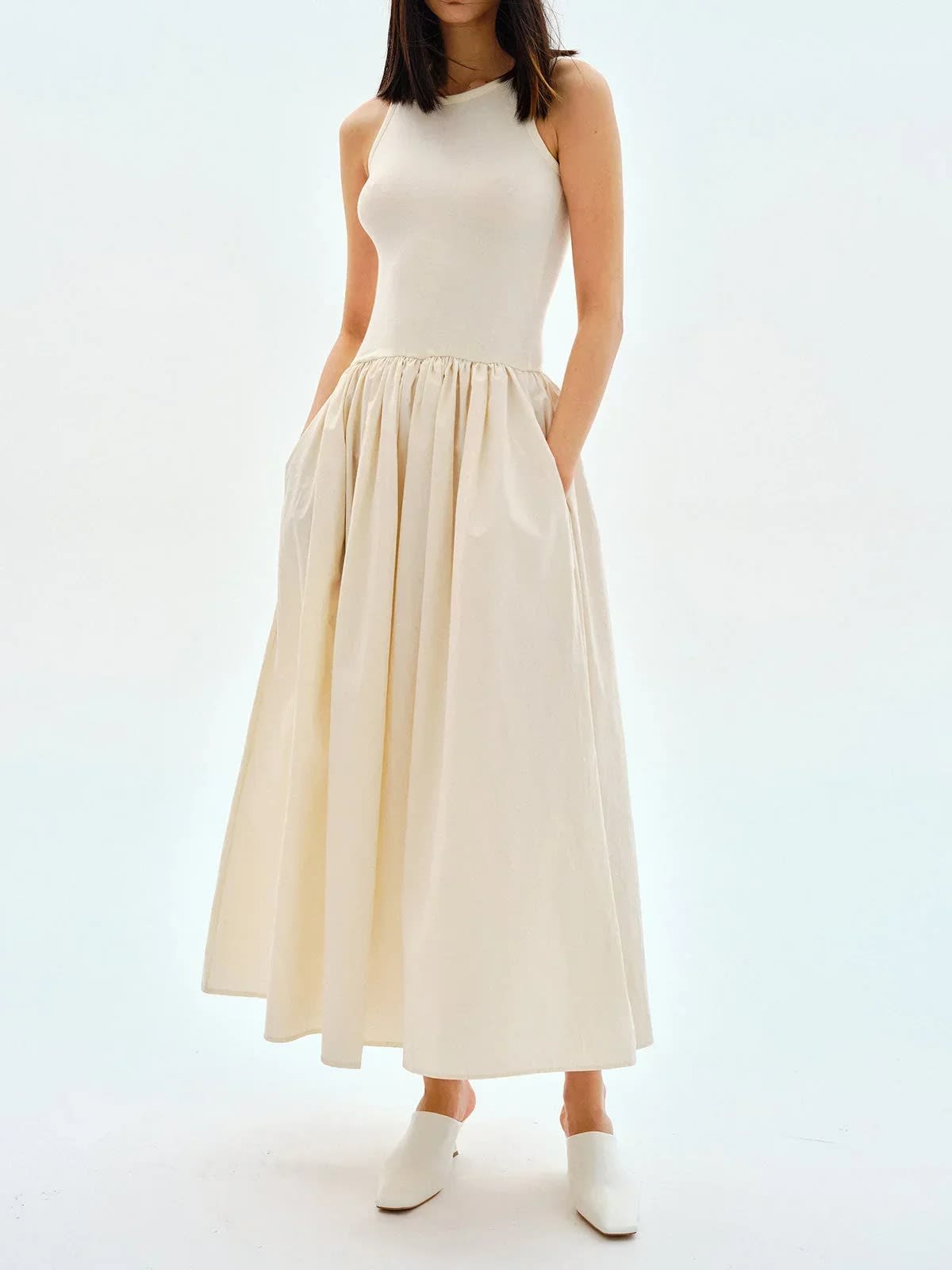 Person wearing a sleeveless maxi dress with a gathered skirt.