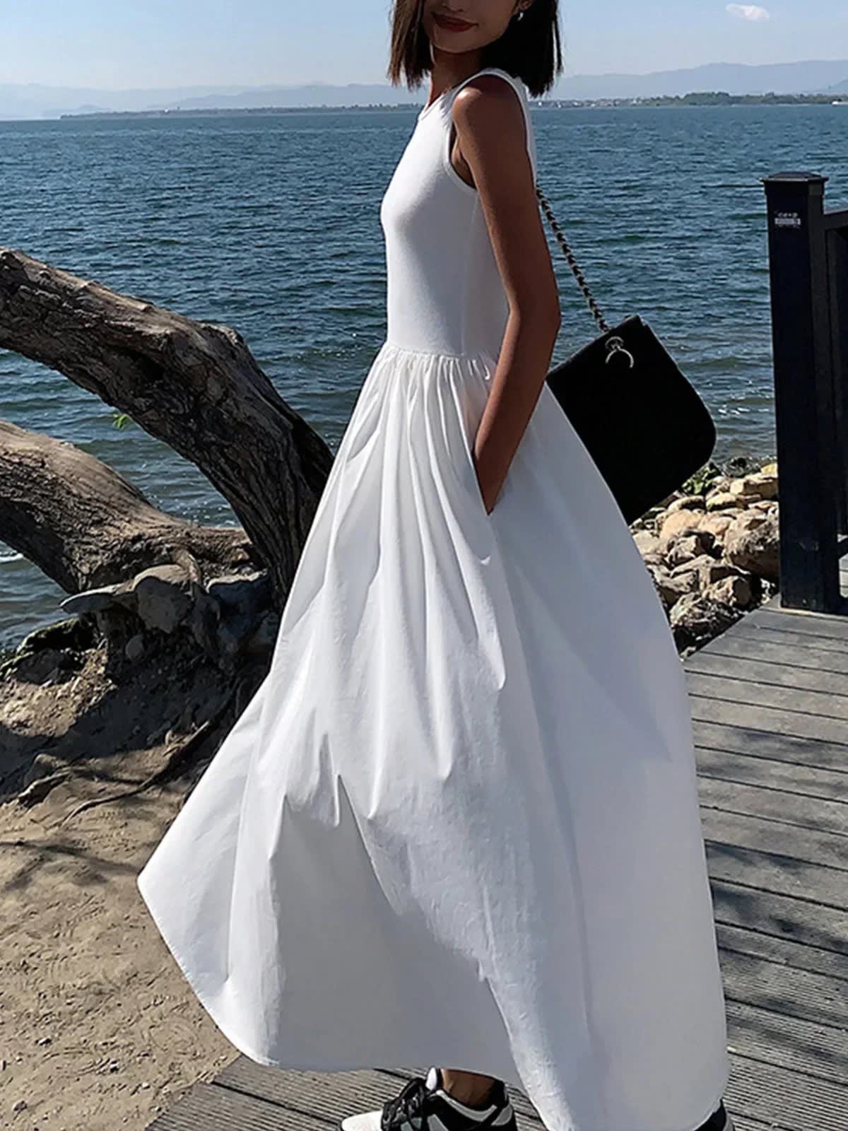 Person wearing a sleeveless maxi dress with a gathered skirt.