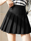 Person wearing a pleated mini skirt with a striped top.