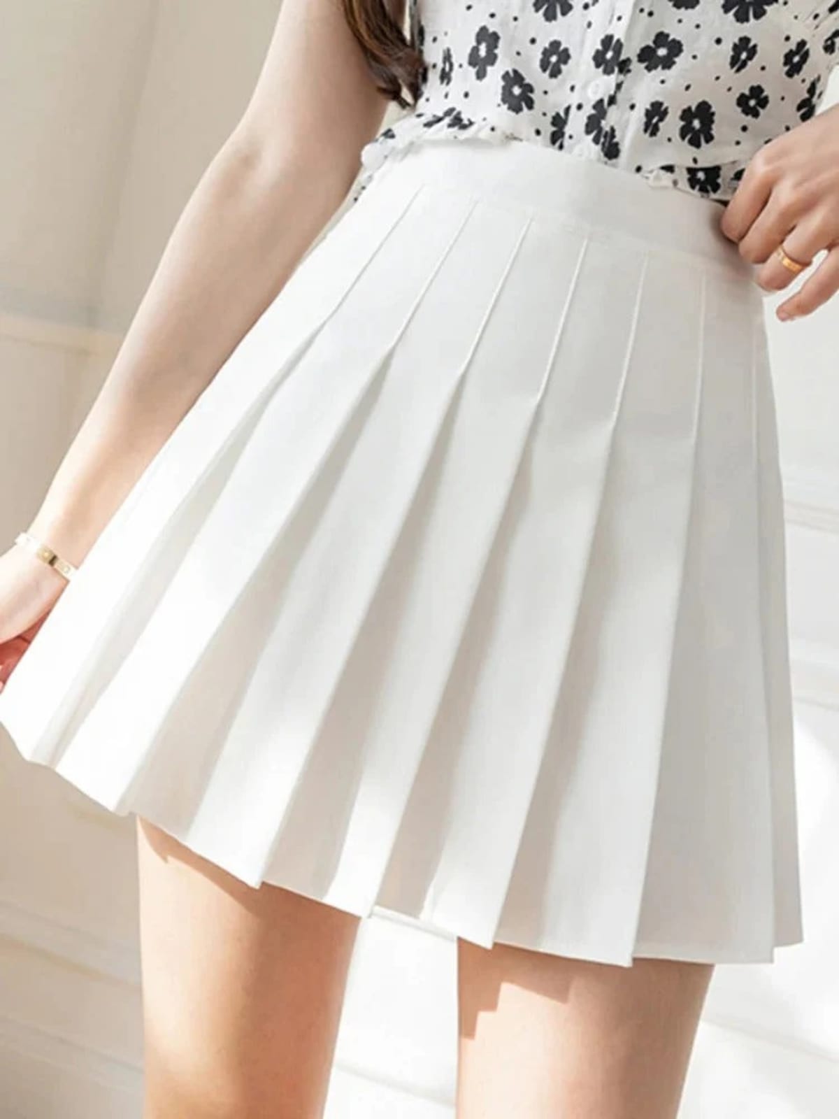Person wearing a pleated mini skirt with a striped top.