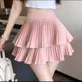 Light pink pleated tiered mini skirt with ruffle hem and wide waistband.