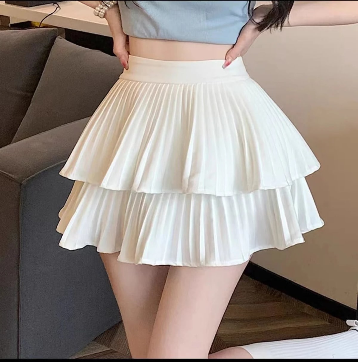Light pink pleated tiered mini skirt with ruffle hem and wide waistband.