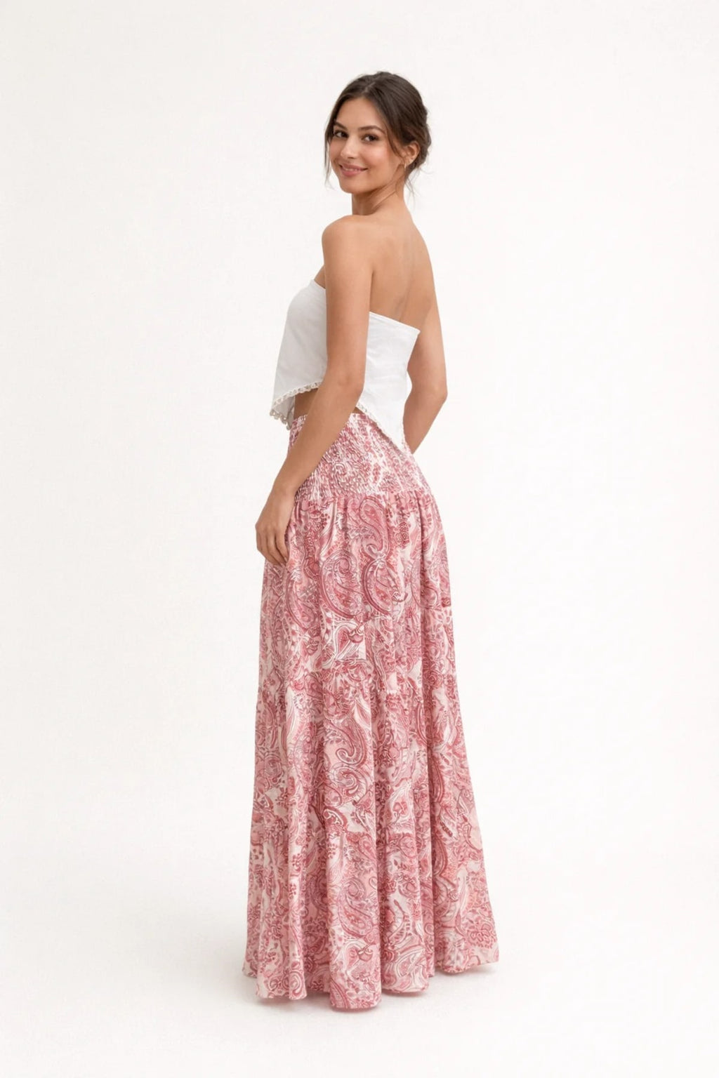 Woman in strapless crop top and tiered maxi skirt set.