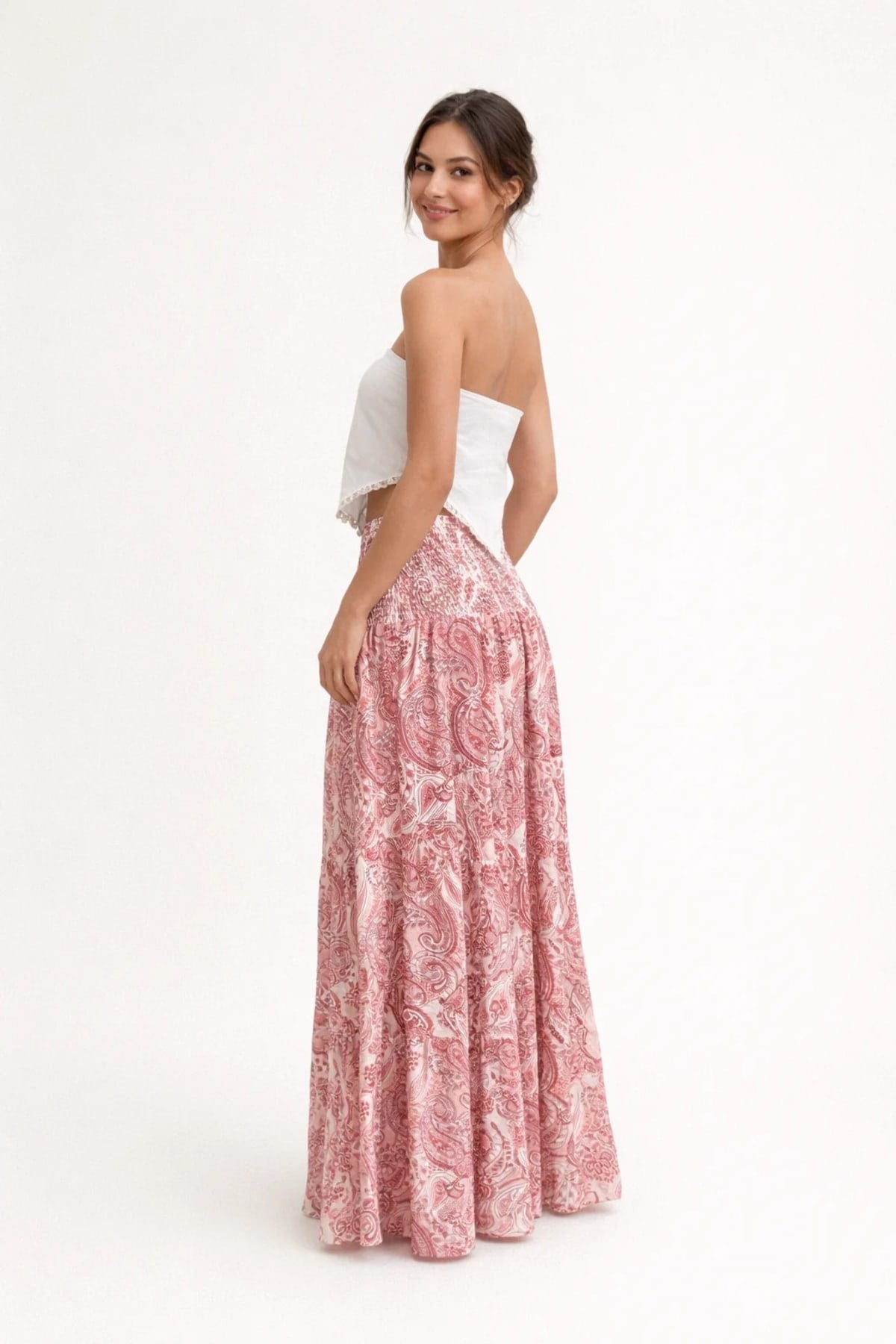 Woman in strapless crop top and tiered maxi skirt set.