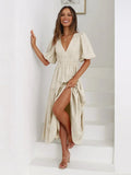 Woman in V-neck maxi dress with puff sleeves and smocked waist.