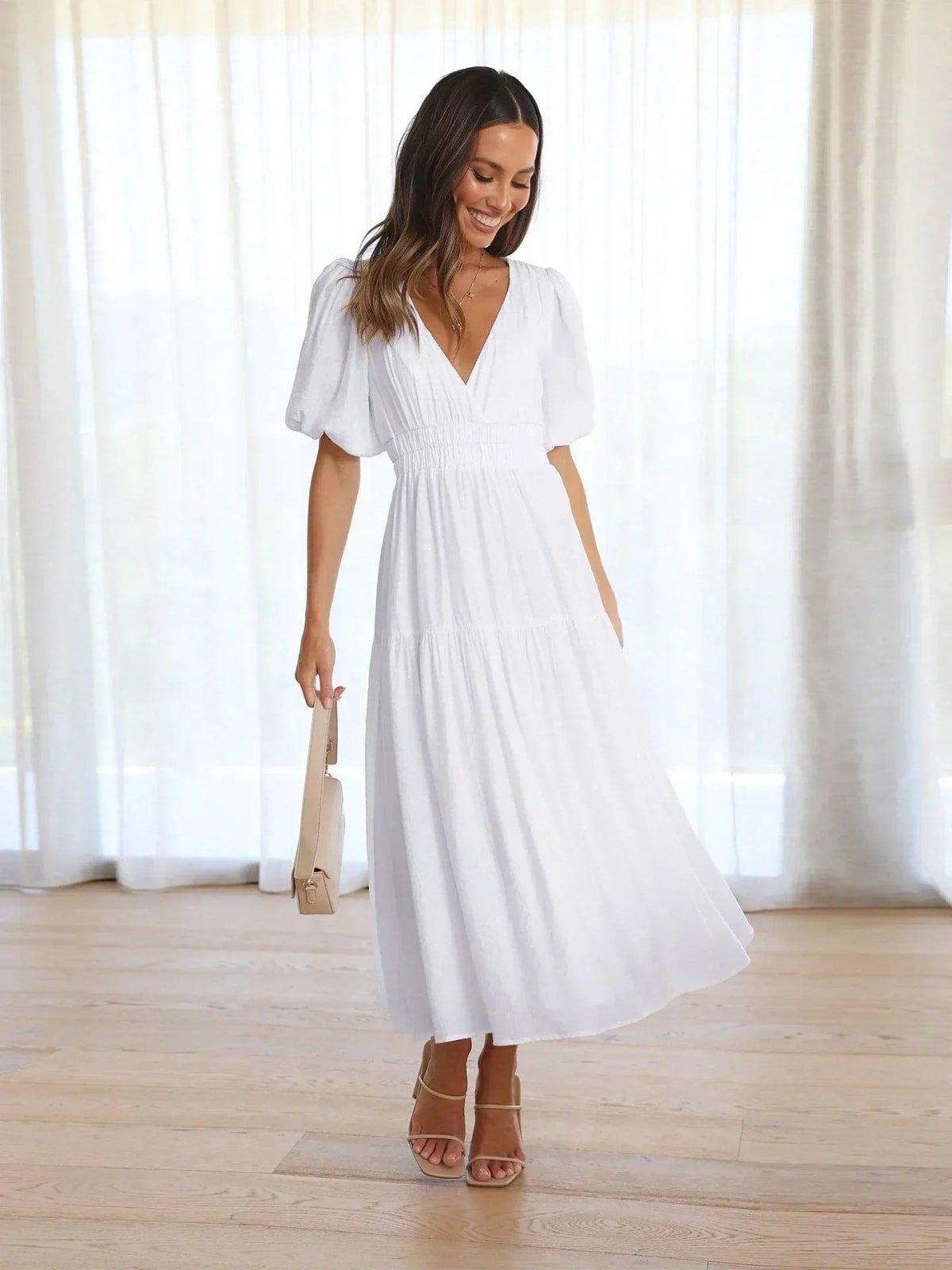 Woman in V-neck maxi dress with puff sleeves and smocked waist.