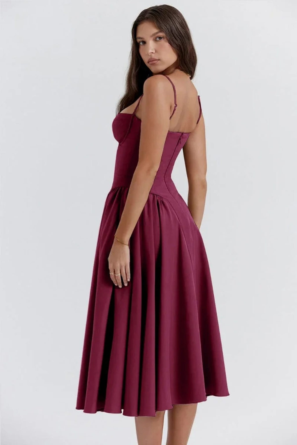 Woman in strapless midi dress with corset bodice and flowy skirt.