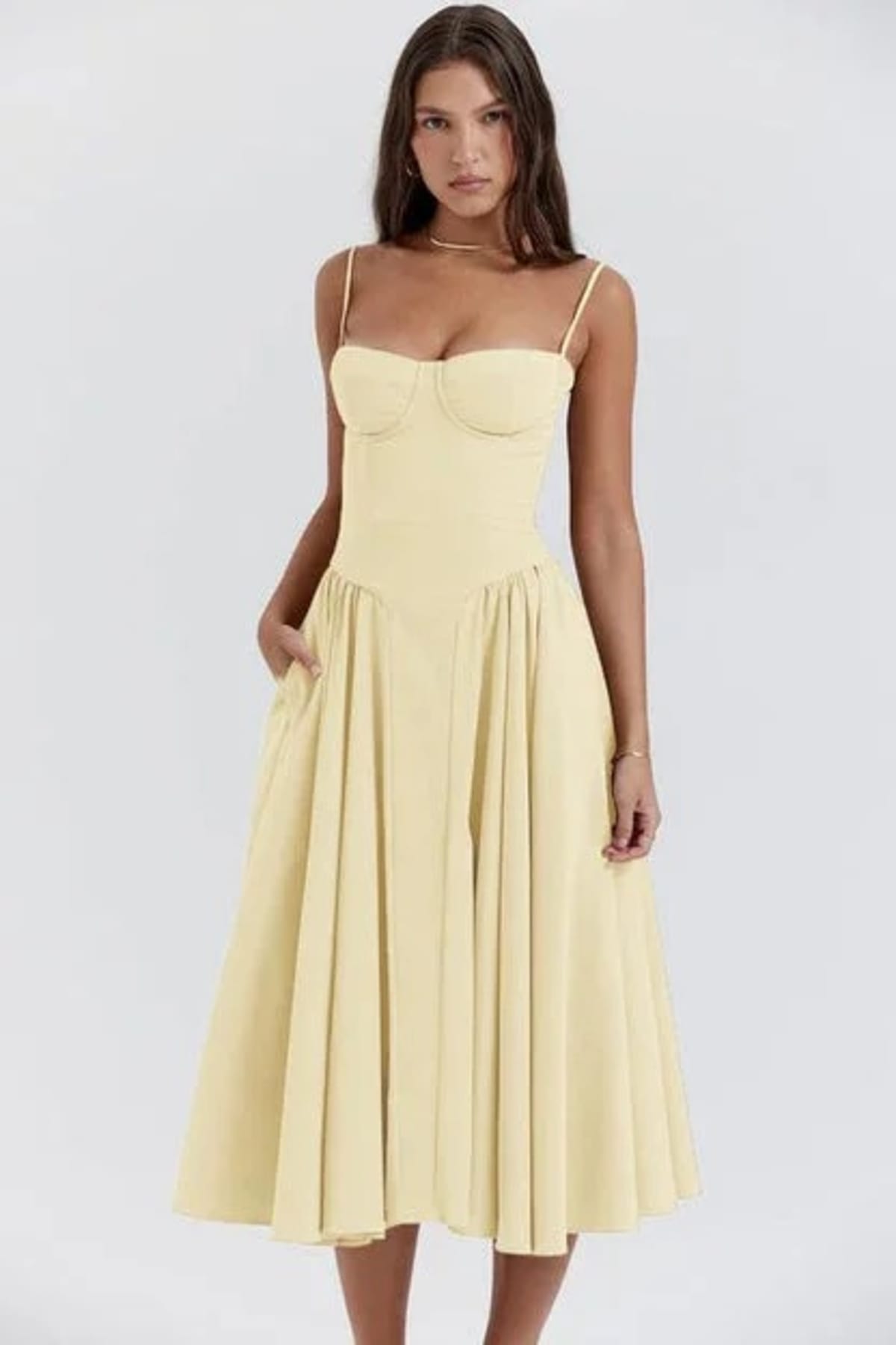 Woman in strapless midi dress with corset bodice and flowy skirt.