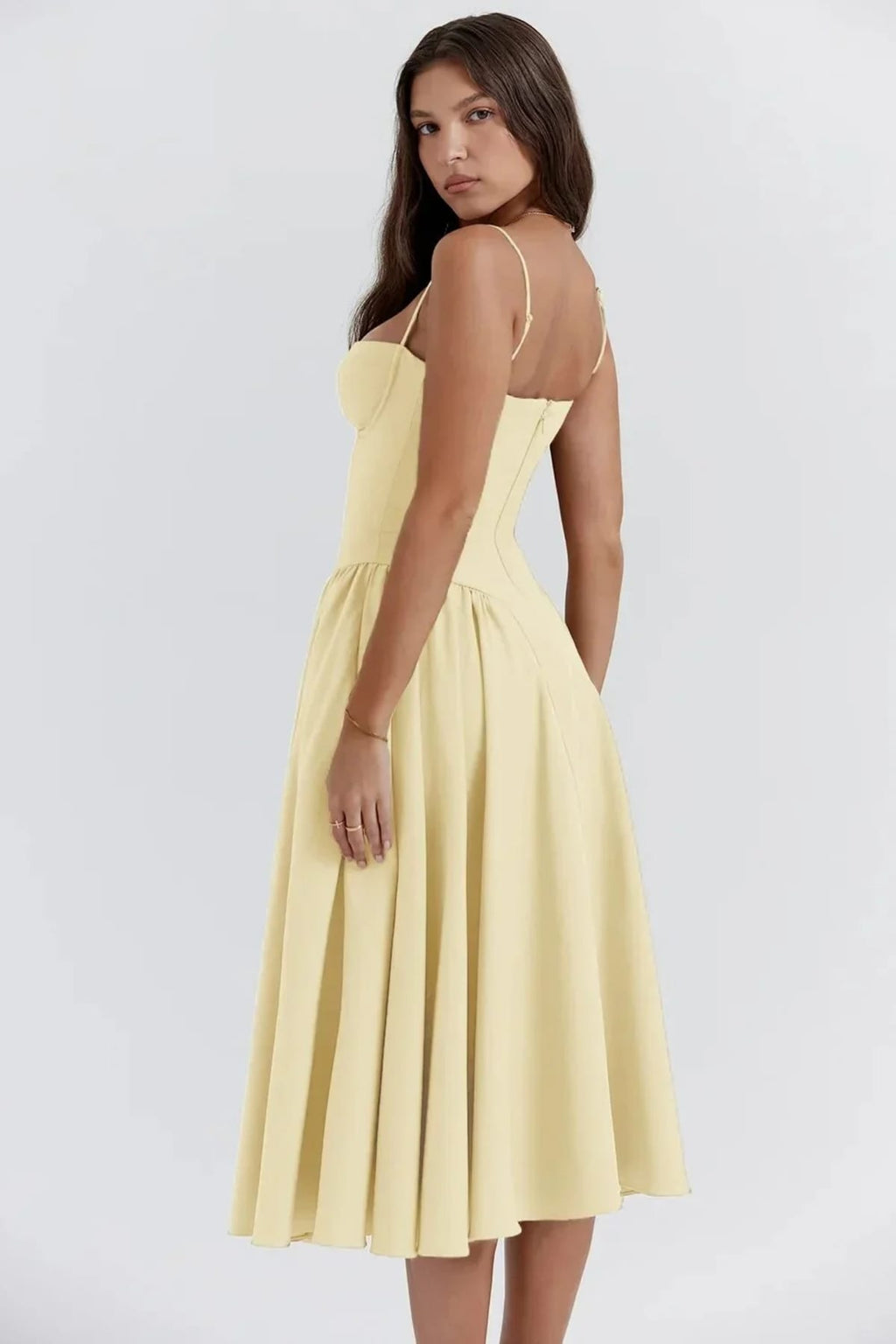 Woman in strapless midi dress with corset bodice and flowy skirt.