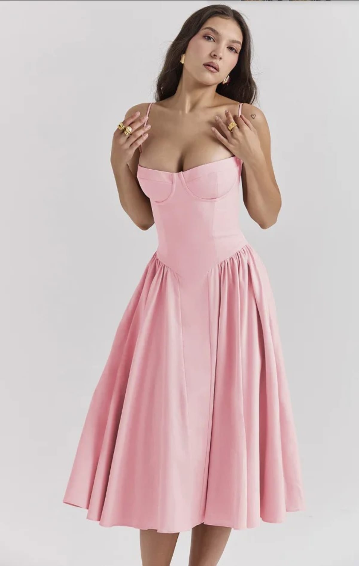 Woman in strapless midi dress with corset bodice and flowy skirt.