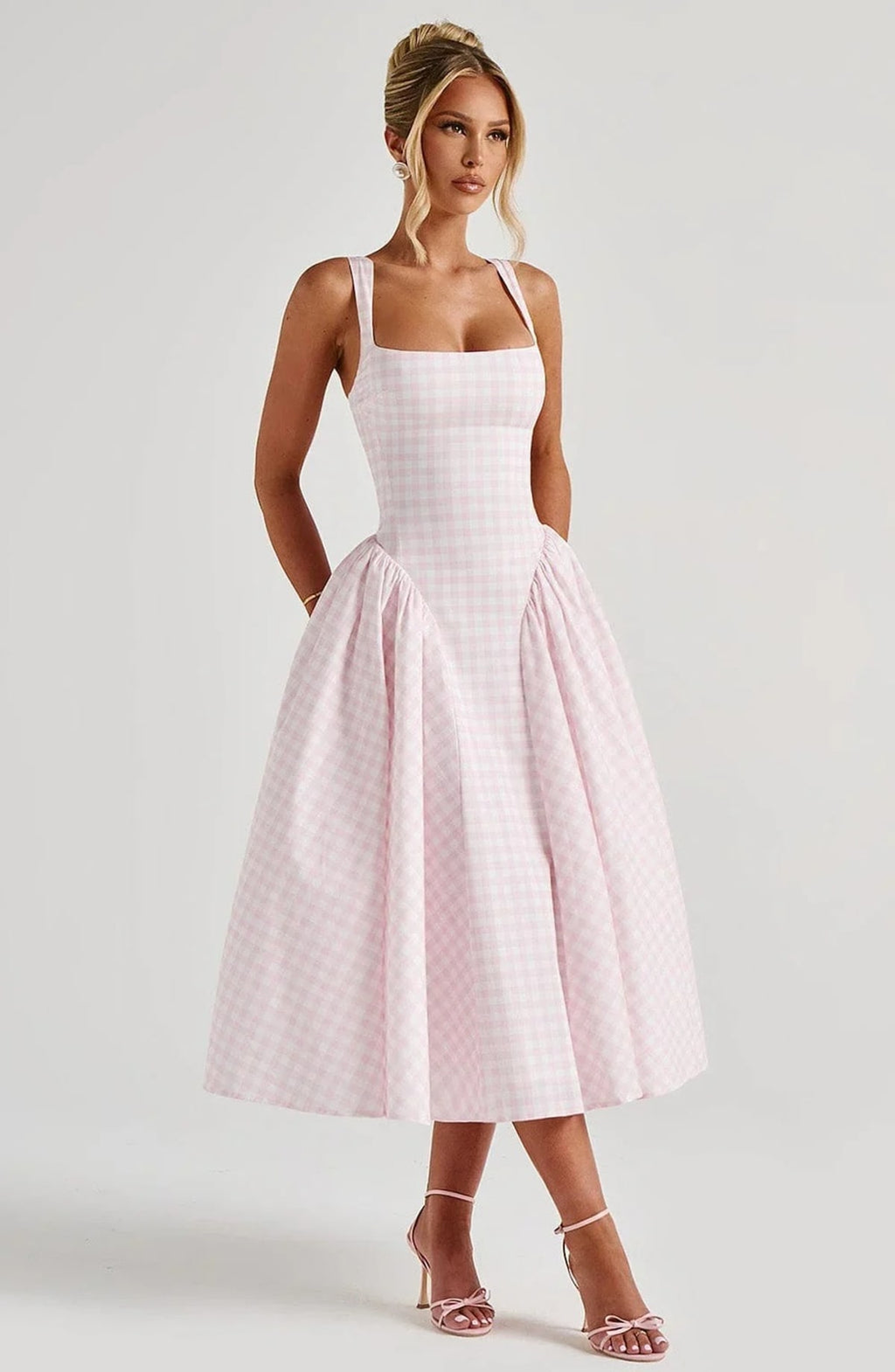 Woman wearing a gingham midi dress with a structured bodice.