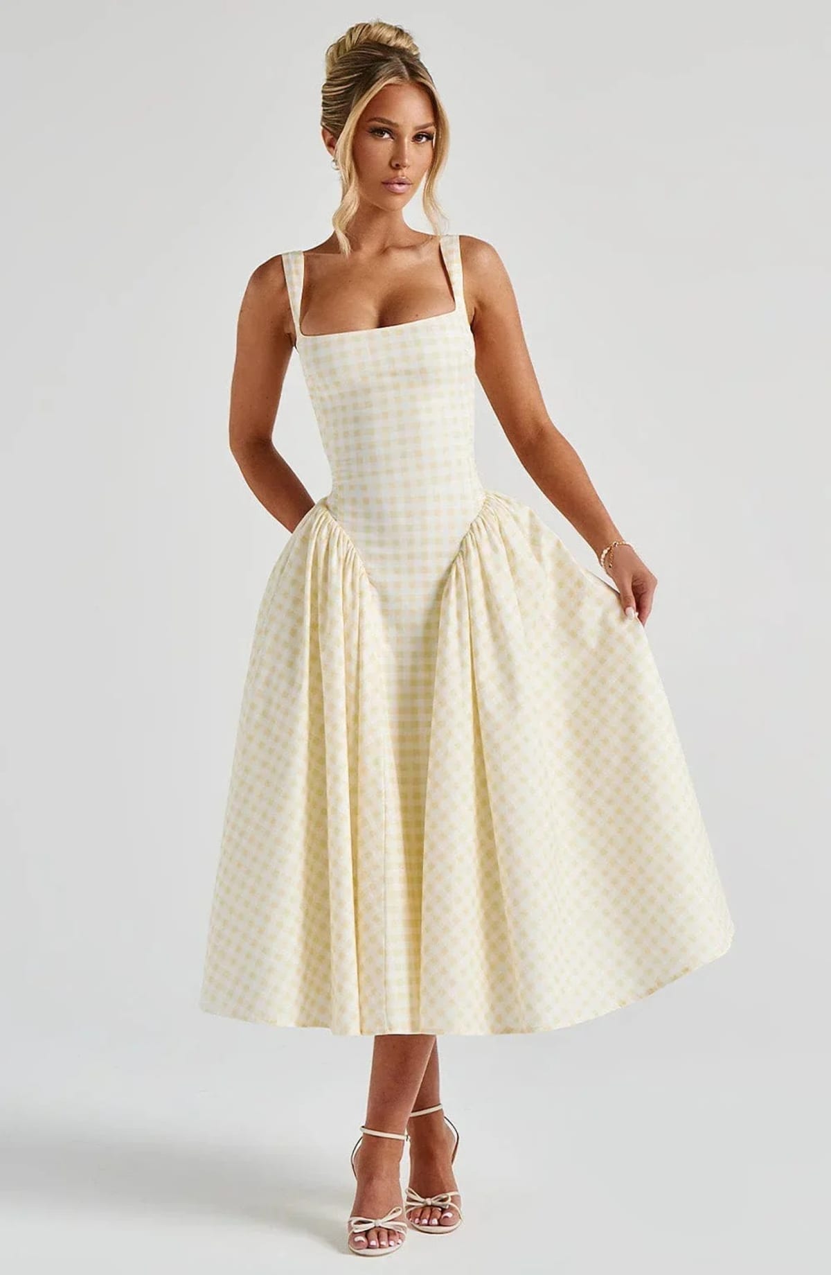 Woman wearing a gingham midi dress with a structured bodice.