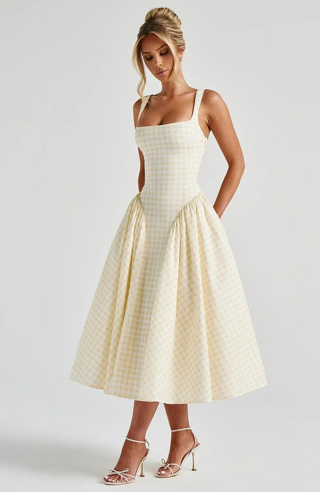 Woman wearing a gingham midi dress with a structured bodice.