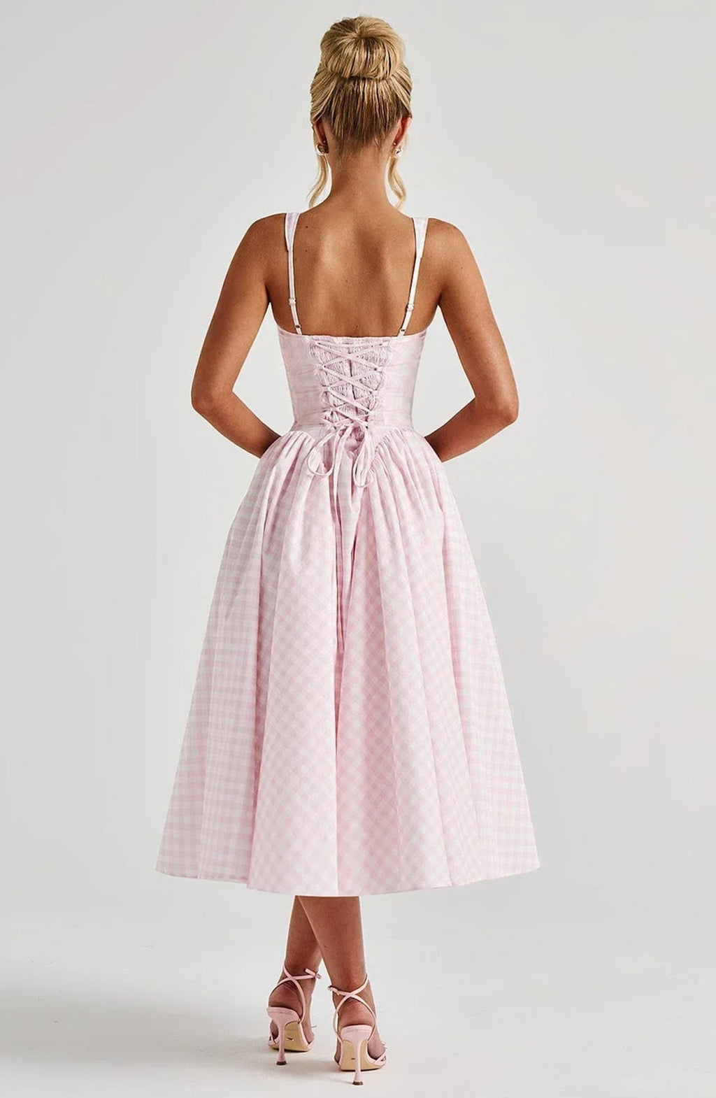 Woman wearing a gingham midi dress with a structured bodice.