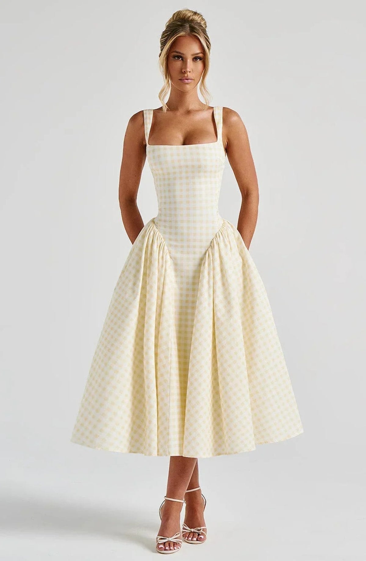 Woman wearing a gingham midi dress with a structured bodice.