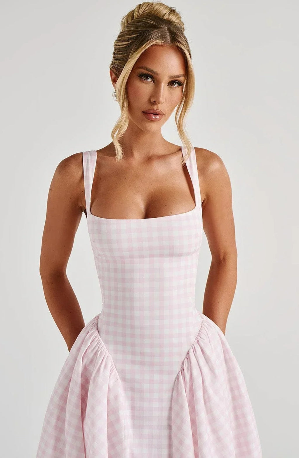 Woman wearing a gingham midi dress with a structured bodice.