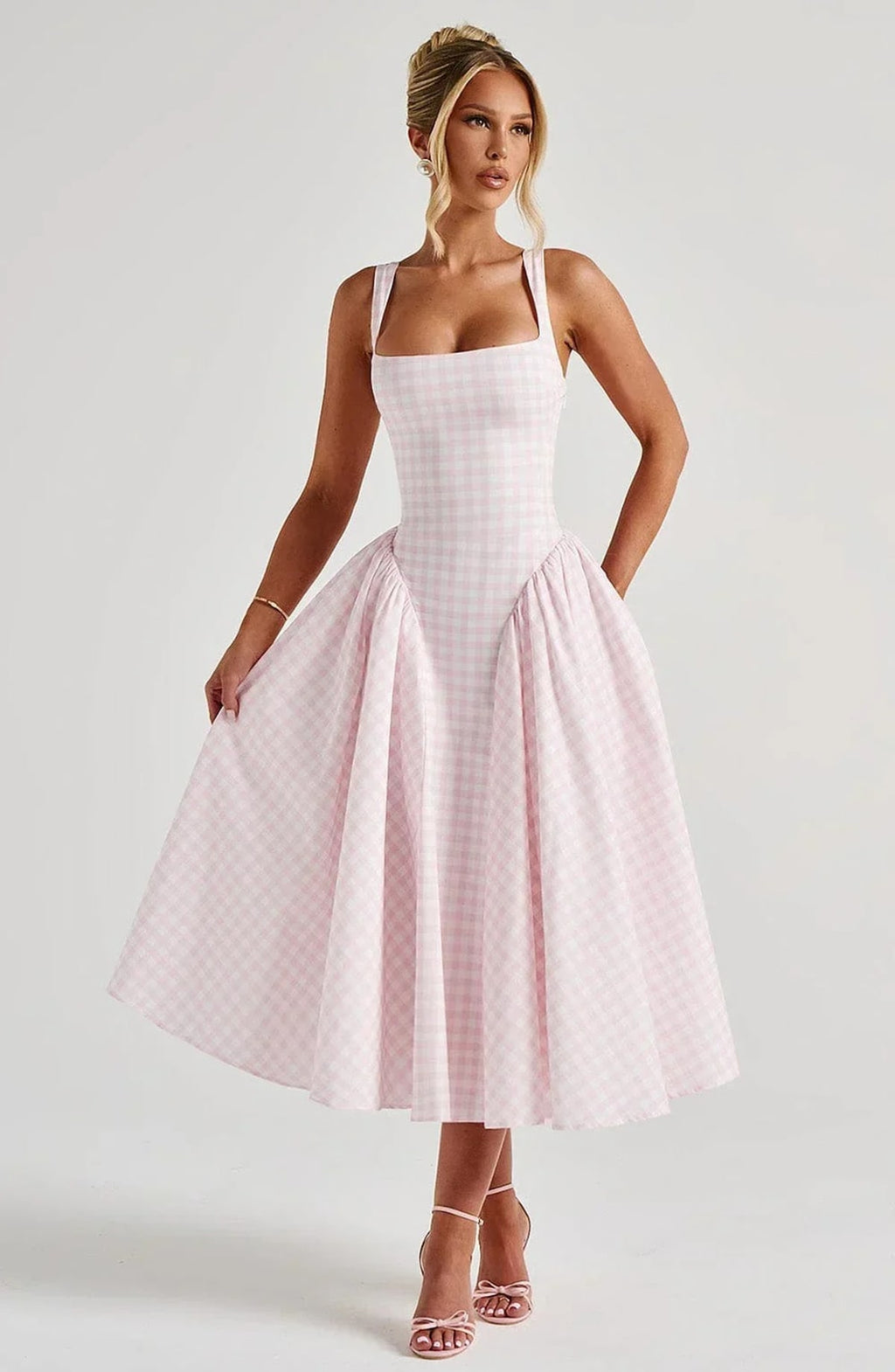 Woman wearing a gingham midi dress with a structured bodice.
